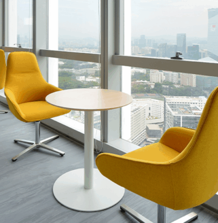 Handshake over a table of office furniture blueprints