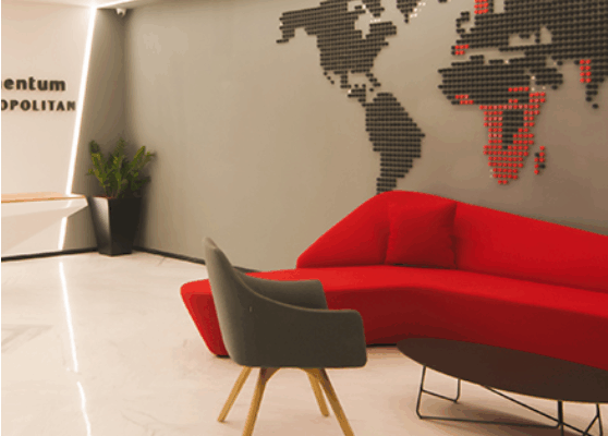 Modern office breakout area with comfortable chairs and tables